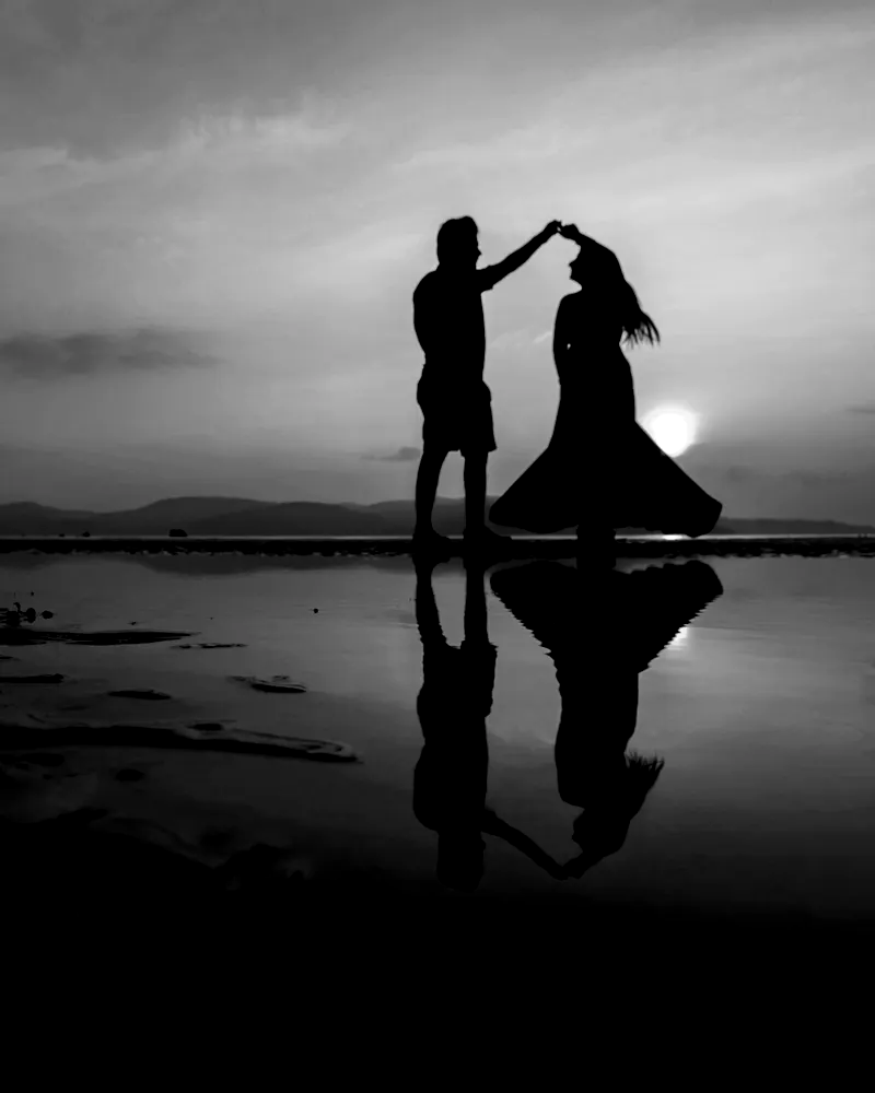 Black and white print: a couple dancing in silhouette at the water’s edge