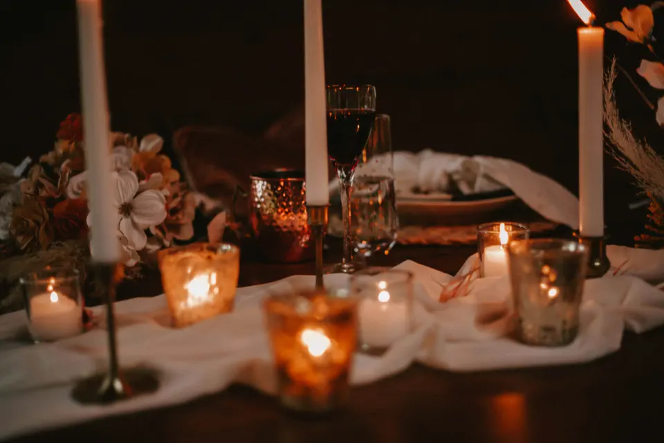 A reception table glowing with candles and draped linen